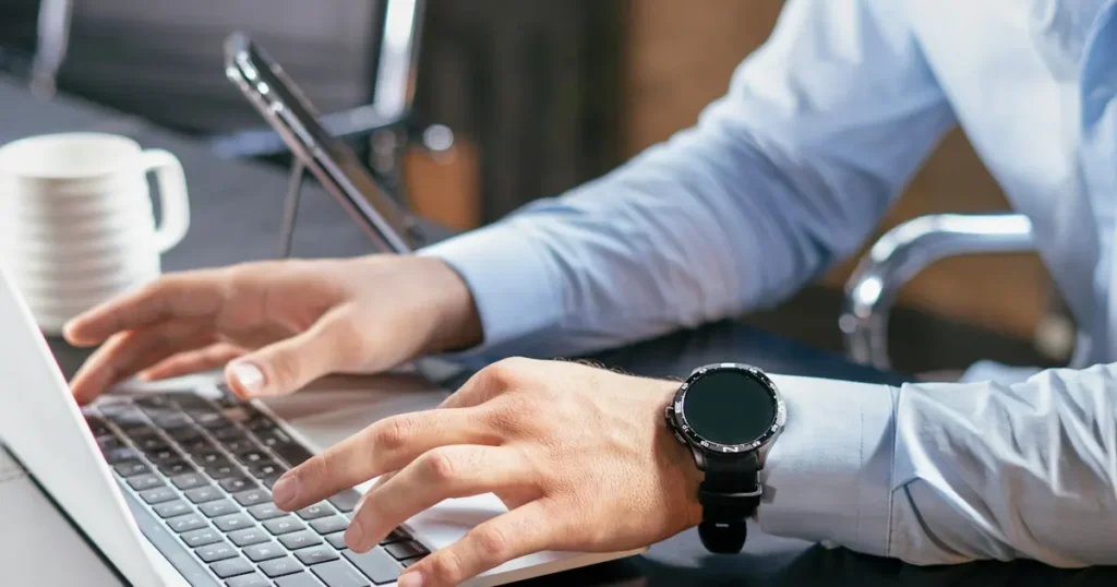 Business owner typing on a laptop at an office desk while checking ACH processing time for customer bank payments