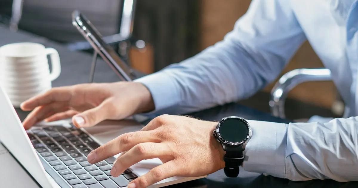 Business owner typing on a laptop at an office desk while checking ACH processing time for customer bank payments