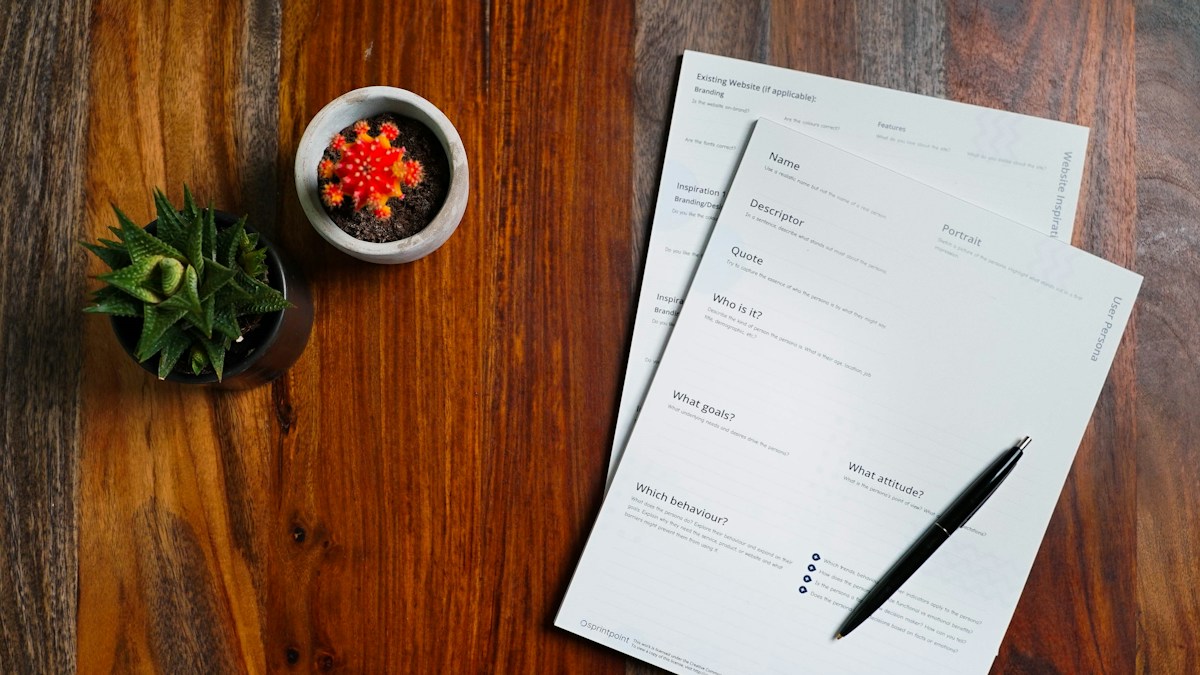 Printed compliance forms and a pen on a wooden desk, representing supplement labeling and claims review