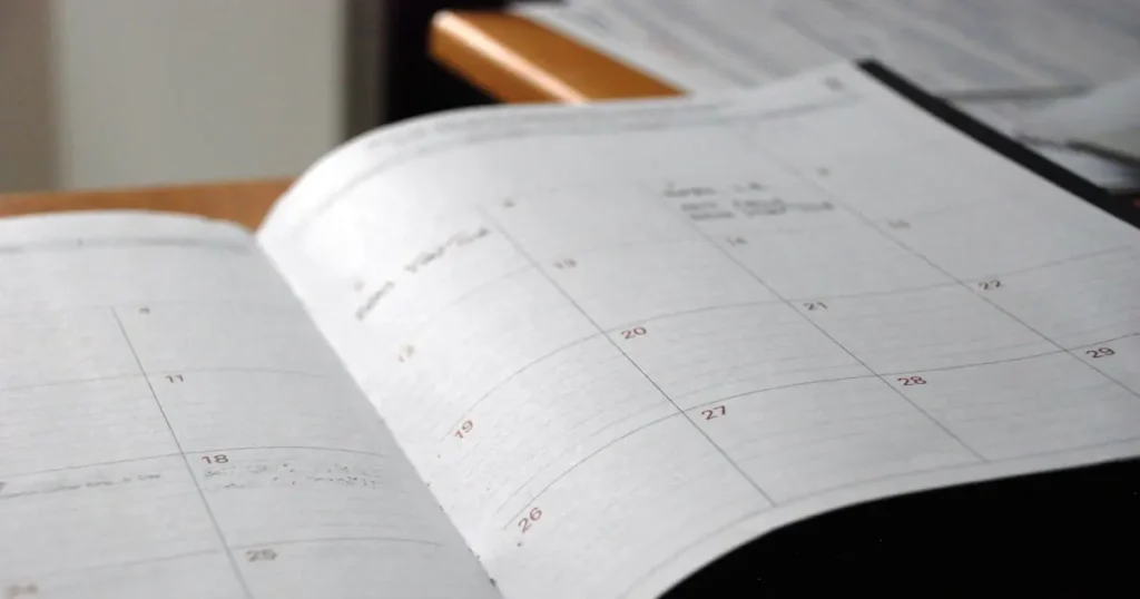 Open monthly planner on a desk, showing how long does it take to get a merchant account from application to approval