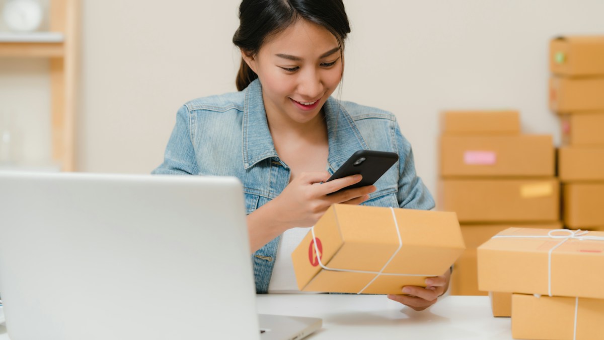 Online seller scanning a packed order with her phone before shipping, a habit that helps keep customer disputes and chargebacks low