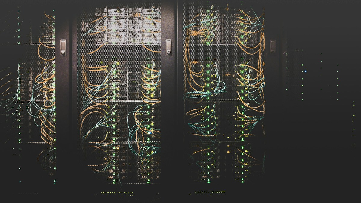 Server racks with network cables in a dark data center, the kind of infrastructure a payment gateway runs on to tokenize and route transactions