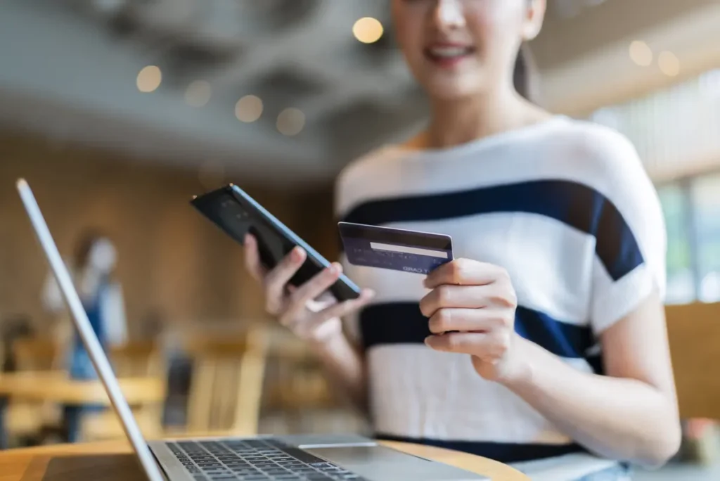 attractive casual smart asian female woman online shopping with-credit card with merchant account in retail shop