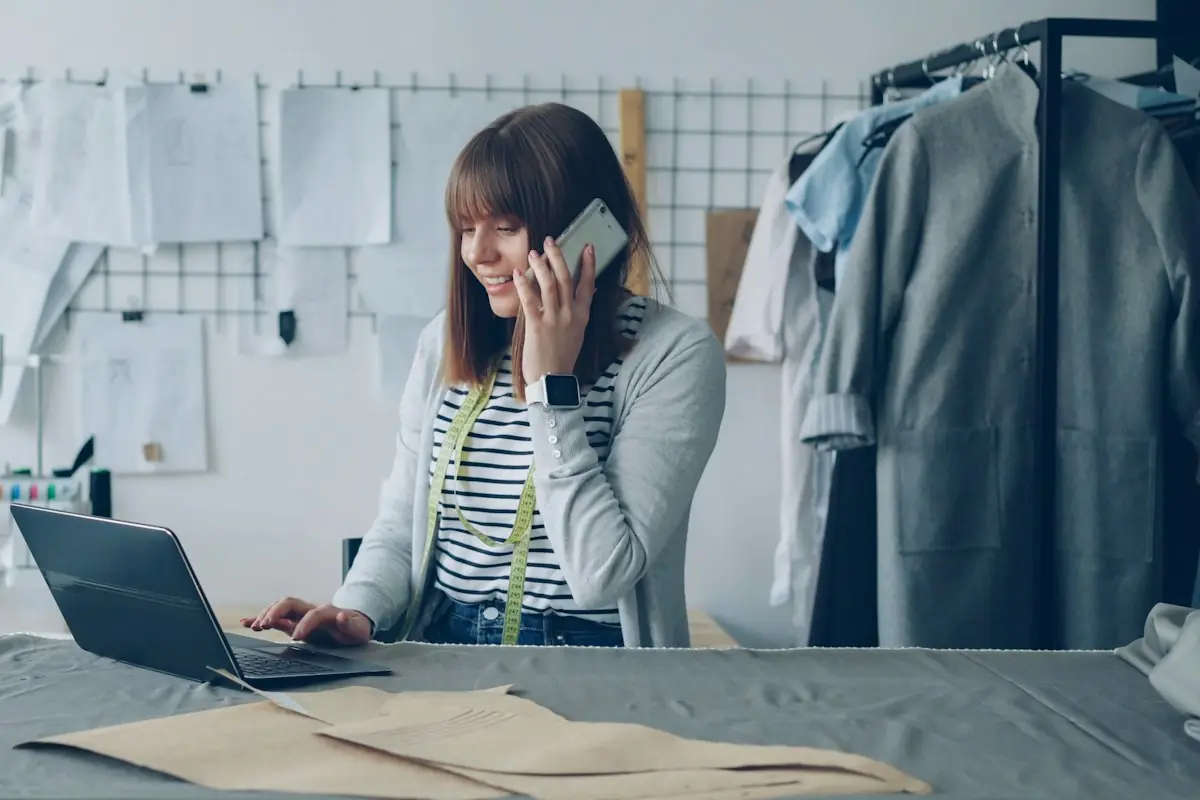 Small business owner answering a customer by phone and laptop to resolve an issue before it becomes a chargeback